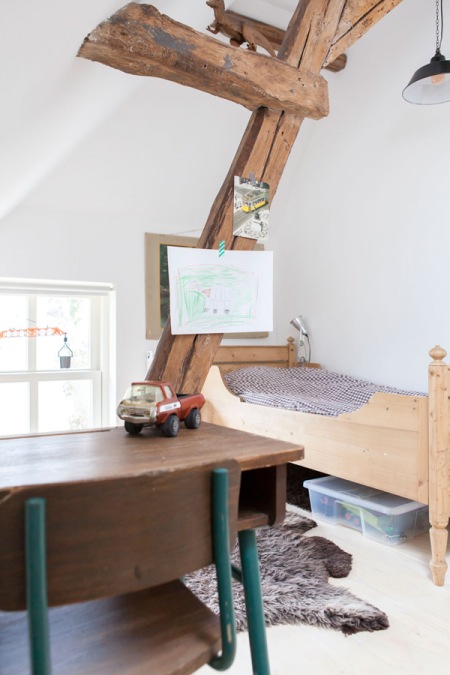Drewniane  belki i podpory  i niebieska metalowa szafa w dziecięcym pokoju