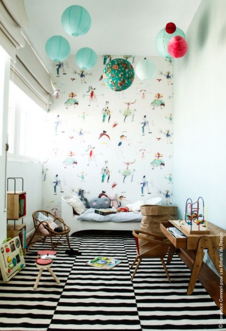 Zielone,turkusowe i miętowe kule z dekoracyjnego papieru wiszące nad łóżkiem w dziecięcym pokoju
