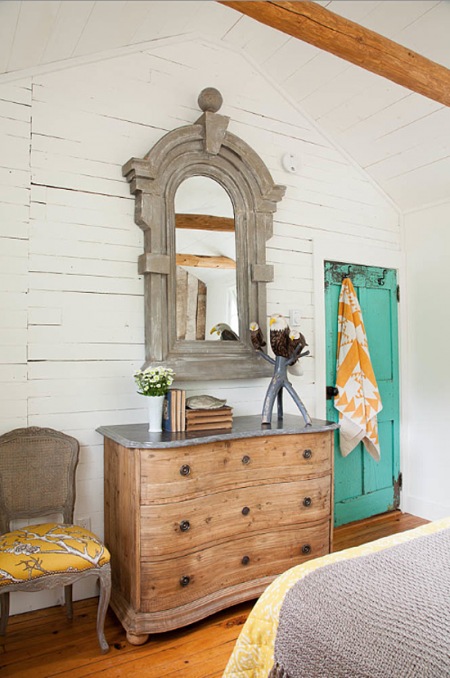 Miętowe drzwi i drewniane meble w sypialni na poddaszu
