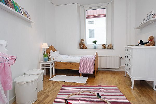 Pokój dziecięcy z drewnianym łóżkiemi różowymi dekoracjami