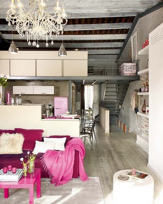 Sofa w kolorze fuksji i różowy koc i stolik  w szaro-srebrnym salonie