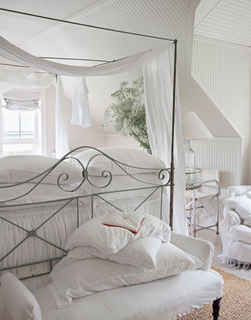 Kute szare łóżko i tapicerowana biała ławka w sypialni