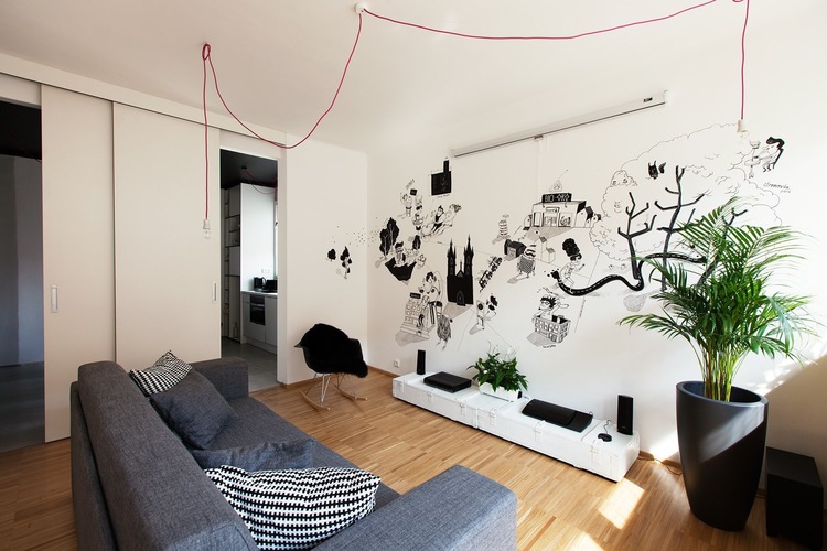 Nowoczesny salon z czarnymi grafikami, różowymi kablami z żarówkami i nowoczesnymi dodatkami