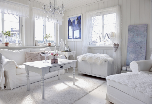 Biała komoda ,biały stolik kawowy z szufladą,biała sofa i kryształowy stylowy zyrandol w skandynawskim salonie w tradycyjnym stylu