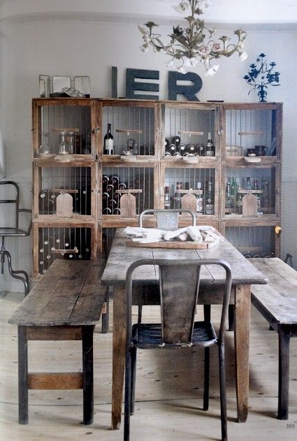 Drewniany stół z ławkami i metalowe krzesła w stylu vintage,drewniano-druciany otwarty regała na wino w jadalni