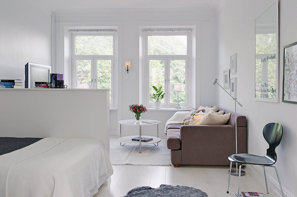 Salon z aneksem na łózko w aranzaxcji jednopokojowego mieszkania w stylu skandynawskim