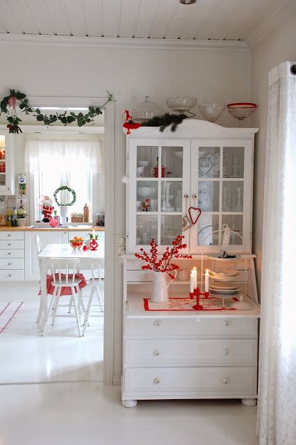Biały skandynawski kredens z czerwonymi dekoracjami świątecznymi