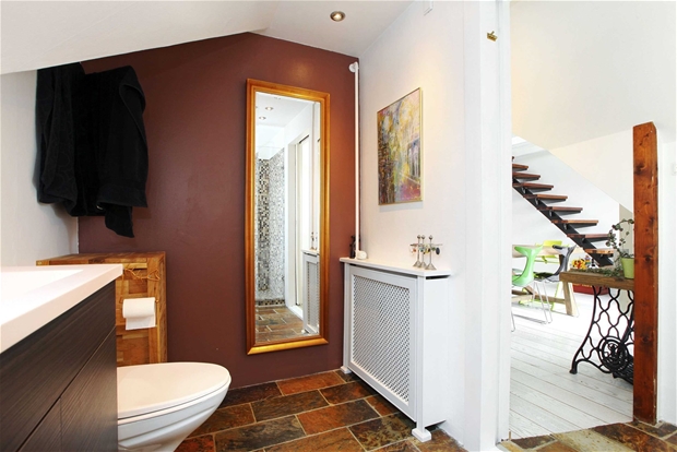 Brązowa ściana i tradycyjna hiszpańska terakota na podłodze w łazience