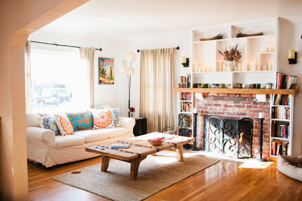 Przytulny salon z bialą sofą i kominkiem z czerwonej cegły