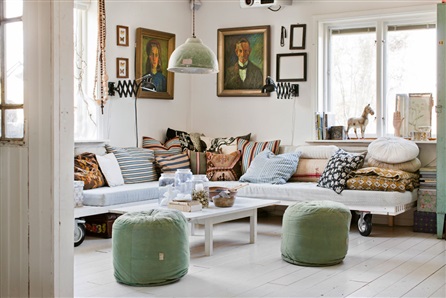 Miętowe pufy,sofa na paletach z kółkami i rodzinne portrety  w białym salonie