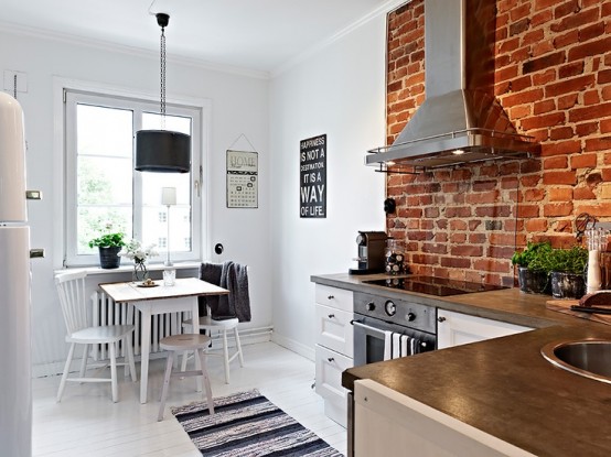 Mała kuchnia skandynawska z elementem ściany z czerwonej cegły