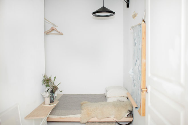 Minimalistyczne łóżko z drewna w małej sypialni