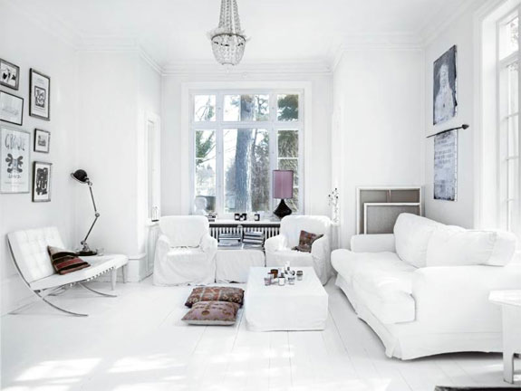 Białe sofy i fotele z kryształowym żyrandolem w salonie