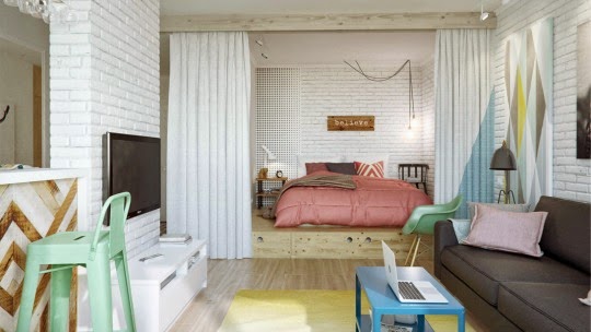 Łóżko na podestach z szufladami oddzielone zasłonami w otwartej zabudowie małego mieszkania