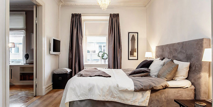 Zasłony i łóżko w kolorze cappuccino w białej eleganckiej sypialni