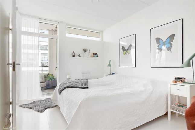 Plakaty z motylami w dekoracji białej sypialni w stylu skandynawskim