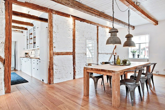 Jadalnia z kuchnią ze ścianami z białej cegły i drewnianymi belkami