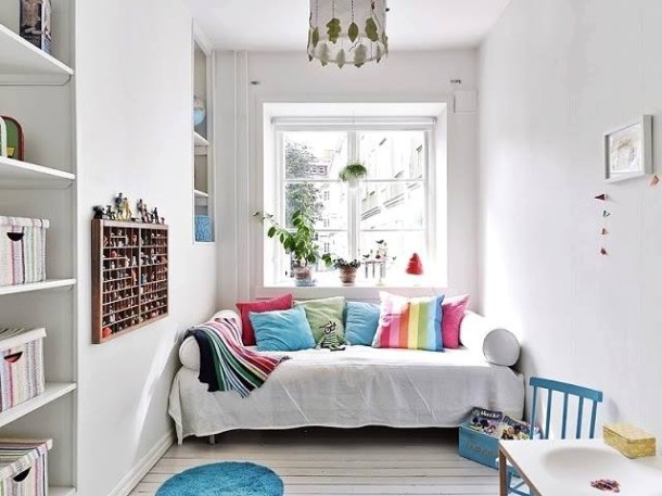 Różowo-niebieskie poduszki i pledy w białym pokoju dla dziecka