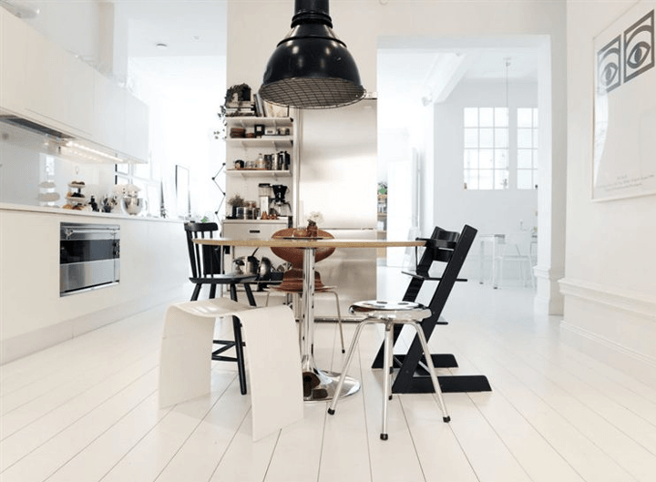 Idealna skandynawska kuchnia w bieli ze stołem z mieszanymi krzesłami