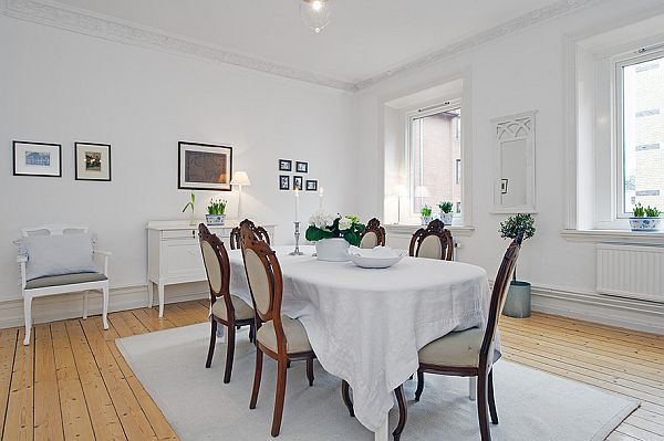 Brązowe stylowe krzesła i tradycyjne białe meble skandynawskie w jadalni