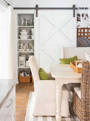 Białe stylowe drzwi przesuwne na żeliwnej ramie na ścianie z półkami w jadalni