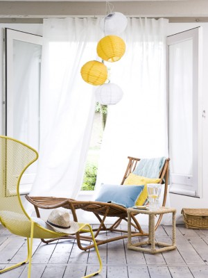 Żółty fotel i  lampy z niebieskimi poduszkami