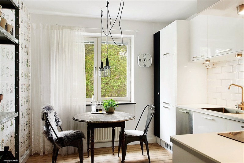 Stylowy stół okrągły,lampy przemyslowe na kablu,regał i krzesła metalowe TOLIX w białej kuchni skandynawskiej