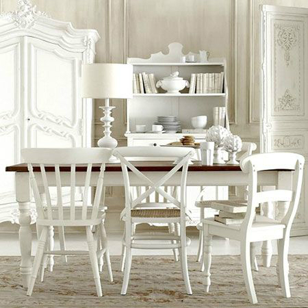 Drewniany stół na toczonych białych nogach z różnymi modelami białych krzeseł