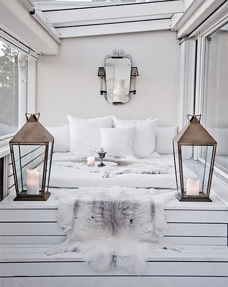 Sypialnia na podeście z białych desek z romantycznymi lampionami