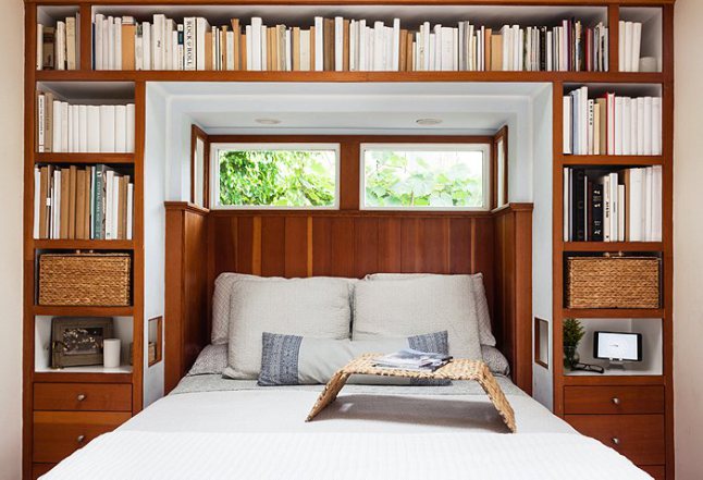 Pomysł na małą sypialnię z regałami na książki wokół łóżka i okna