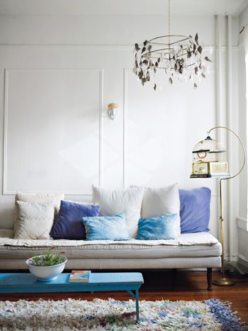 Niebieskie poduszki dekoracyjne na białej sofie w salonie