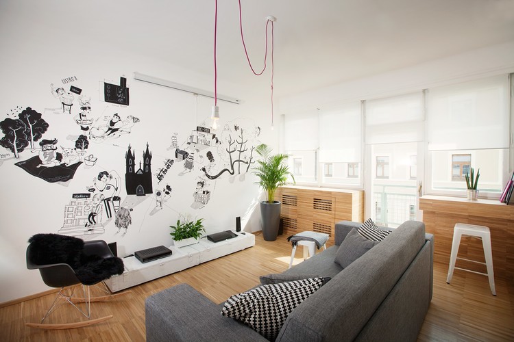 Szara sofa , czarne grafiki i różowe kable z żarówkami w aranżacji nowoczesnego salonu