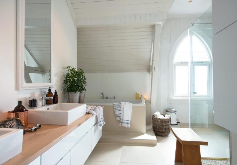 Skandynawska łazienka na poddaszu w oknem z dziewiętnastowiecznym łukiem