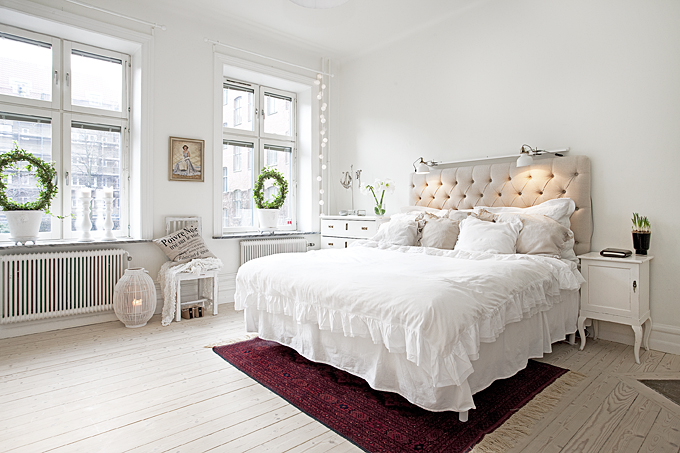 Romantyczna sypialnia z pikowanym wezgłowiem przy łóżku