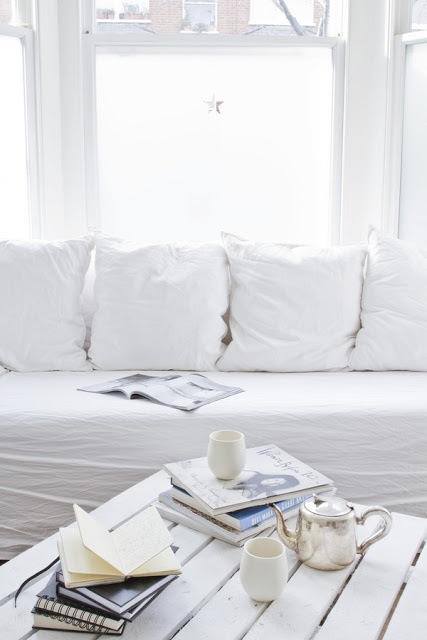 Śnieżnobiała sofa z poduszkami i białymi detalami