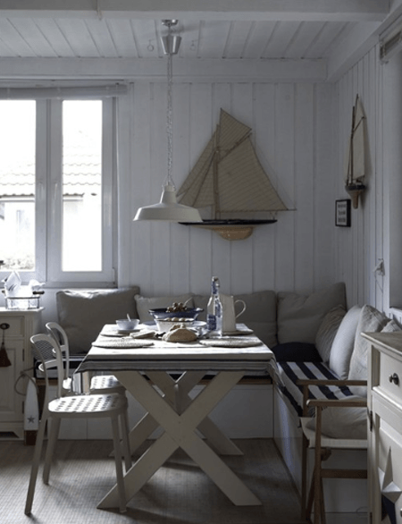 Drewniane,. białe ławki w jadalni przy stole