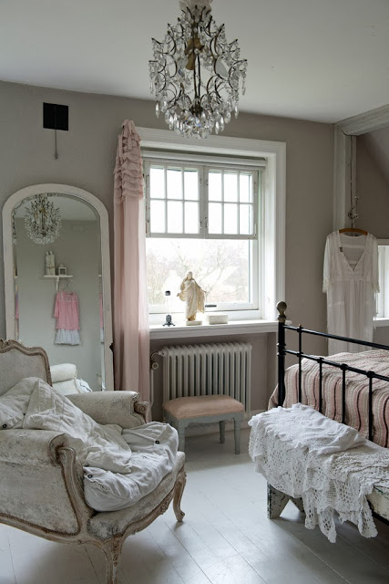 Romantyczna sypialnia z kutym łóżkiem i kryształowym żyrandolem