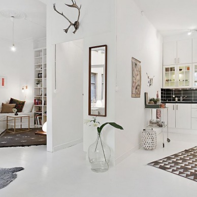 Mieszkanie o nieregularnym kształcie i powierzchni 50 m2 z białą podłogą i skandynawskim duchem