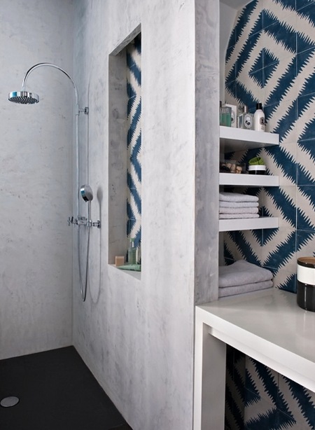 Grafitowa żywiczna posadzka,stiukowe ściany i geometryczna biało-niebieska glazura w łazience