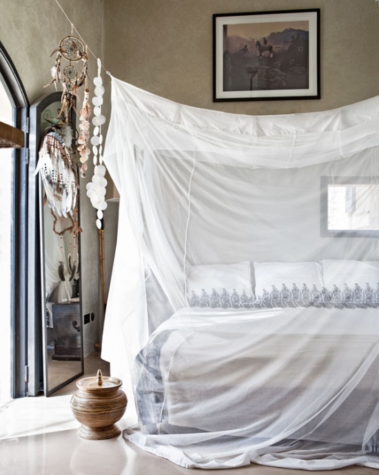 Śródziemnomorskie muszelki,orientalne naczynia i betonowe ściany w aranżacji sypialni z białym woalowym baldachimem
