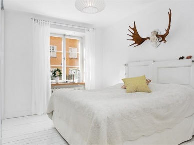 Białe łóżko vintage , poroże jelenia w aranżacji białej sypialni (24870)