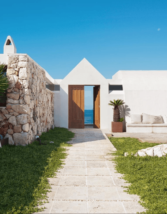 Białe ściany wapienne, naturalny kamień i drewno w śródziemnomorskiej architekturze