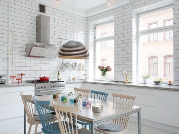 Beżowe i niebieski drewniane krzesla skandynawskie przy jednym stole w białej  kuchni (25421)