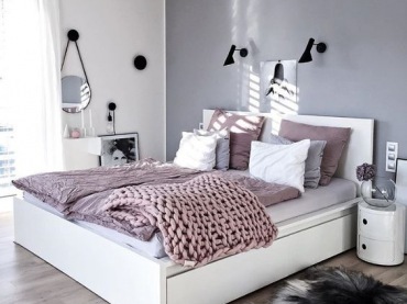 Puszysty dywanik obok łóżka w sypialni dodaje wnętrzu przytulności. Delikatne kolory szarości i różu przełamują...
