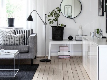 Białe meble do szarej sofy to typowe i ponadczasowe połączenie w skandynawskich aranżacjach. Czarne dodatki w postaci...