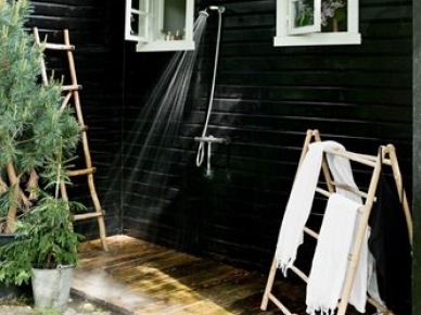 Deszczownia natrysk i drewniane wieszaki drabinki na zewnątrz małego czarnego domku w stylu skandynawskim (25561)