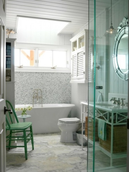 Białe skandynawskie i tradycyjne meble w łazience,turkusowe krzesło,owalne lustro w stylu glamour i wiklinowe kosze pojemniki z ręcznikami