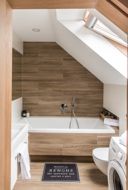 Mała łazienka z drewnianymi panelami na poddaszu