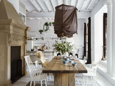 Drewniany masywny stół w jadalni, razem z cegłami i drewnem na podłodze oraz suficie zdradza zamiłowanie właścicieli do...