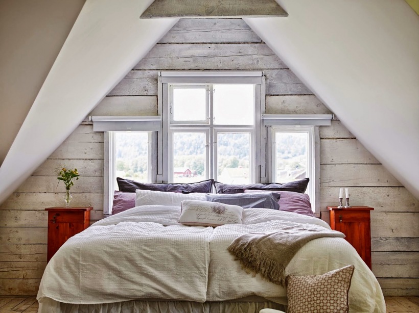 Czereśniowe drewniane stoliki nocne w sypialni pod drewnianym skośnym dachem